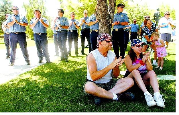 Brad Horn/Nevada Appeal Russ and Susan Wheaton, above,  of Nevada Street, five block from burned Rupert&#039;s Auto Body, applaud at the picnic on the Legislative lawn on Sunday. Carson City firefighters from left first row, Jesse Rowan, Gary Garrett, Bob Stanford and captains John Bergstrom and Bob Schreihans look on.
