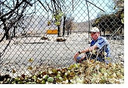 BRAD HORN/Nevada Appeal Cyril Ouilette sits in the side yard of his home that burned down in the Waterfall fire where he lived for 12 years.