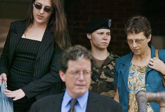 Pfc. Lynndie England, background center, is flanked by her mother Terrie England, right, Kristin DiDonato, a member of her legal team, left, and Xavier Anador, bottom, as she leaves the Staff Judge Advocate Building at Fort Bragg, N.C., Thursday, Aug. 5, 2004, at the end of the third day of her Article 32 hearing. The Article 32 hearing will determine whether England will face a court-martial on 13 counts of abusing detainees and six counts stemming from possession of sexually explicit photos. The maximum possible sentence is 38 years in prison. (AP Photo/Bob Jordan)