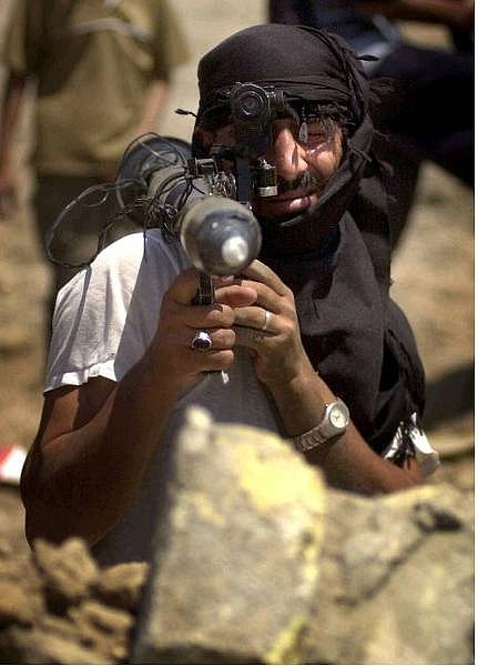 A follower of Shiite cleric Muqtada al-Sadr carrying an RPG launcher takes to the streets in the southern Iraqi city of Basra, Monday Aug. 9, 2004.  The British military said it had reports that 150 militants were walking through Basra demanding all shops be closed. The Mahdi Army threatened Monday to take over local government buildings in Basra if U.S. troops did not leave Najaf, and also said they would target oil pipelines and ports in southern Iraq.  (AP Photo /Nabil Juranee)