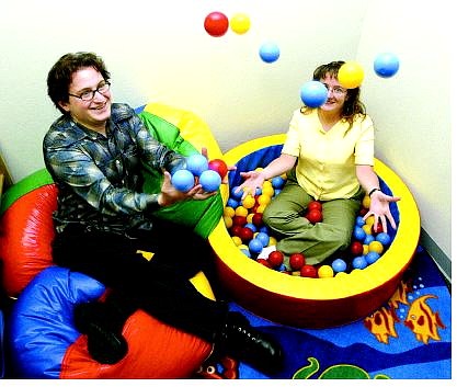 The Ron Wood Family Resource Center and Family to Family Connection joined forces at 212 E. Winnie Lane. Joseph Warren, left, Volunteer in Service to America representative for the foundation, and Sharlea Payne, executive director of Ron Wood Family Resource Center, play in the toddler room of the newly combined center.  Belinda Grant Nevada Appeal
