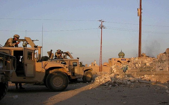 American soldiers aim towards Mahdi army positions at the world&#039;s largest cemetery in the holy Shiite city of Najaf, Thursday Aug. 12, 2004.  U.S. forces suspended a major offensive against militants in Najaf on Friday, Aug. 13, 2004 as Iraqi officials and aides to radical Shiite cleric Muqtada al-Sadr met to try to negotiate a truce to end nine days of fighting in the holy city. (AP Photo/Tod Pitman)