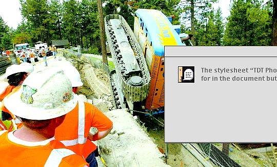 Jim Grant/Tahoe Daily Tribune Nevada Department of Transportation workers look down on a home crushed by a drilling rig along Highway 50 near Zephyr Cove Thursday morning.