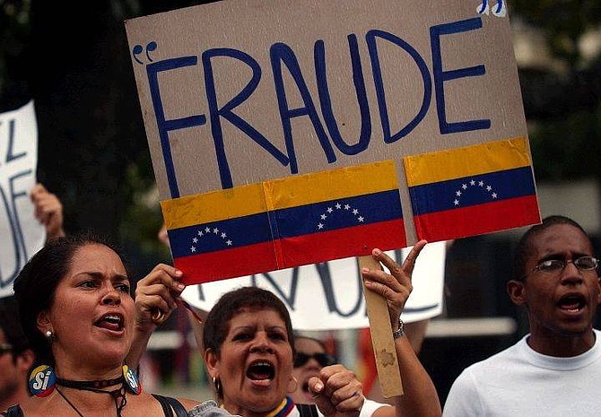 With a sign saying &quot;Fraud&quot; people protest outside of a hotel in Caracas, Venezuela Monday Aug. 16, 2004 over the victory of Venezuelan President Hugo Chavez in the Aug. 15th recall referendum against his rule.(AP Photo/Dario Lopez-Mills)