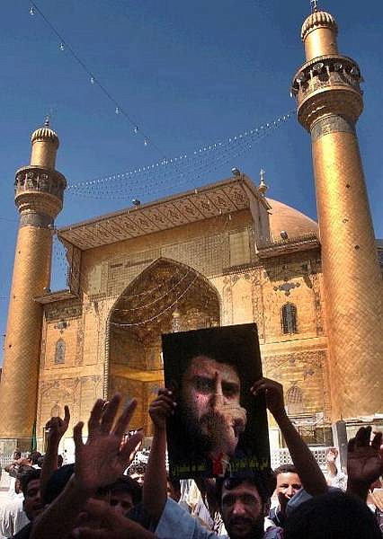 Iraqis loyal to radical Shiite cleric Muqtada al-Sadr hoist pictures of al-Sadr as they rally in the Imam Ali mosque complex as clashes take place between U.S. and Iraqi soldiers with Sadr&#039;s militia in the southern Iraqi city of Najaf,  Monday Aug. 16, 2004. Delegates at Iraq&#039;s National Conference called on radical Shiite cleric Muqtada al-Sadr to abandon his uprising against U.S. and Iraqi troops and pull his fighters out of a holy shrine in Najaf. (AP Photo/Khalid Mohammed)