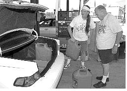 Associated Press John McDonald, left, and his father, Bill, put gas cans back in their car after filling up Friday afternoon in Punta Gorda, Fla. Life is slowly returning to normal as a few gas stations and restaurants are beginning to reopen one week after Hurricane Charley made landfall.