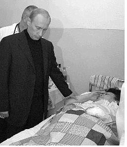 Russian President Vladimir Putin visits a hospital in Beslan, Northern Ossetia, to meet victims of the hostage crisis Saturday. Below, a boy, who wasn&#039;t a hostage, looks around a literature classroom in the school seized by terrorists, in Beslan, North Ossetia on Saturday. More than 350 people were killed in a southern Russian school that had been seized by militants, a prosecutor said Saturday.    Associated Press