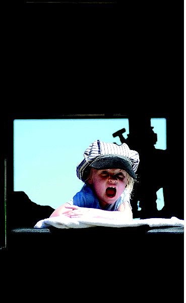 BRAD HORN/Nevada Appeal Annaka Jahn, 2, of Carson City sits in Engine No. 25 while her father, Loren Jahn, helps fix a problem with the train at the Nevada State Railroad Museum steam-up on Sunday afternoon.
