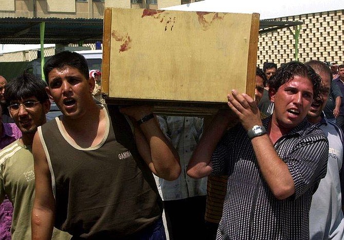 Unidentified relatives carry a body from a hospital morgue for burial in Sadr City, Baghdad, Iraq, Tuesday Sept. 7, 2004.  U.S. forces battled al-Sadr&#039;s supporters in the Baghdad slum on Tuesday, killing at least 34 people, including one American soldier, and injuring 193. (AP Photo/Karim Kadim)