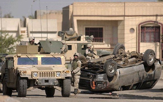 U.S. soldiers stand near a car, reportedly transporting foreigners wearing bulletproof vests and carrying guns, that was attacked by insurgents in Baghdad, Iraq, Wednesday Sept. 8, 2004. Eye witnesses said that more than one person was injured in the attack.  (AP Photo/Khalid Mohammed)