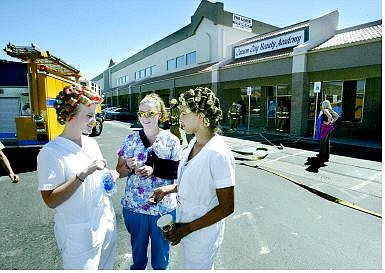 Cathleen Allison/Nevada Appeal Carson City Beauty Academy students, from left, Stacy Ward, Lacy Barcellos and Susy Hurtado wait outside the school Wednesday afternoon after a dryer fire evacuated more than 55 people.