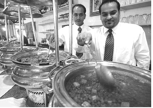 BRAD HORN/Nevada Appeal Bobby Singh, right, and his partner Bishan Singh, look over the buffet at India Curry restaurant in Carson City on Thursday morning before the lunch rush.