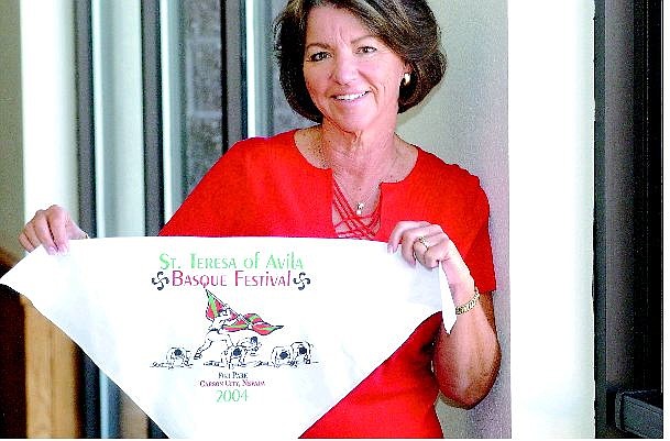 Rick Gunn/Nevada Appeal Mary Ann Randall holds a scarf with the logo of the St. Teresa Basque Festival which will take place at Fuji Park on Sunday. Randall is one of the coordinators and director of religious education.