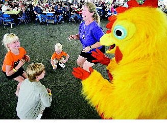 Linda King, aka The Chicken, dances with Ethan Devine, 6, from left, Brianna Vandenhazel, 7, and her brother Nikolaas, 2, and their mother at the Oktoberfest celebration at Mills Park&#039;s Pony Express Pavilion on Saturday afternoon.