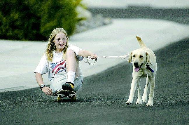 Using a homemade harness, Lenna Fagan takes her dog Goldie on a walk near their Gardnerville home. Top photo, Lenna, who hopes to one day work with animals, has several pets at home including Fez the snake.