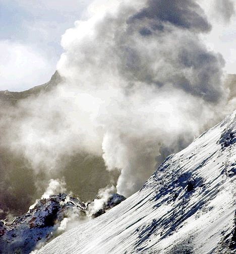 The lava dome, lower left, in Mount St. Helens crater, is surrounded by steam as a large steam vents above the crater rim in southwest Washington Sunday, Oct. 10, 2004.  The volcano began non-stop steam venting early in the continuing into the afernoon. (AP Photo/Don Ryan)