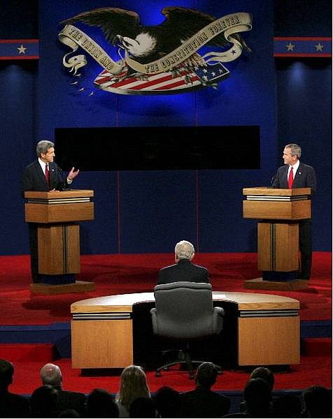 Democratic presidential candidate Sen. John Kerry, D-Mass., answers a question as President Bush listens during the third and final presidential debate in Tempe, Ariz., Wednesday, Oct. 13, 2004. (AP Photo/Ron Edmonds)