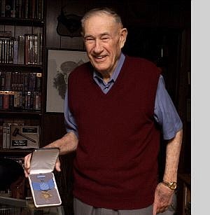 By Little People Portraits. Richard Sorenson displays his Medal of Honor. Sorenson died Oct. 9.