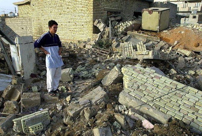 An Iraqi man reviews the damage after a house collapsed following an US military airstrike on Fallujah, west of Baghdad, Iraq, Friday, Oct 15, 2004. By sundown Friday, witnesses reported a series of new airstrikes in the southern and eastern part of the city. According to residents Fallujah has been sealed off by American troops, who prevented residents from leaving the area. (AP Photo/Bilal Hussein)