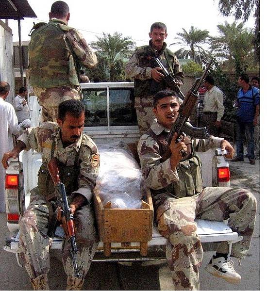 Iraqi national guardsmen arrived with a body of a killed comrade to the morgue in Baqouba, north-east of Baghdad, Iraq, Monday, Oct. 25, 2004. The bodies of about 50 Iraqi soldiers were found on a remote road in eastern Iraq on Sunday. (AP Photo/Sami Aburaya)