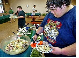 Associated Press Calories are limited at the Academy of the Sierras.Above, Henry fixes a  plate of salad during dining period.
