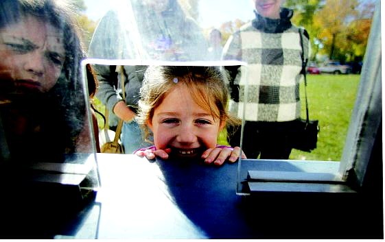 BRAD HORN/Nevada Appeal Jamie Cohen, 4, right, and her sister Laura wait at the ticket booth for the carnival to open at Mills Park on Friday.