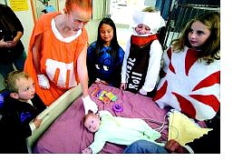 BRAD HORN/Nevada Appeal Trevor Grant, 6-weeks-old, of Smith Valley, receives a Halloween greeting by Charlie Meeks, 4, from left, Briana Rutherdale, 11, Marjorie Meeks, 9, Emily Meeks, 11, and Charlotte Meeks, 11, in the pediatrics ward of Carson Tahoe Hospital on Sunday.