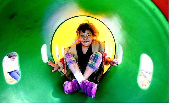 BRAD HORN/Nevada Appeal Kasey Camp, 8, of Carson City, climbs through a tube on the Seeliger Elementary School playground on Thursday afternoon. Camp, who has mild cerebral palsy, was kicked out of the Latch Key program and her mother, Amy Garland, is looking for alternate care but is having difficulty.