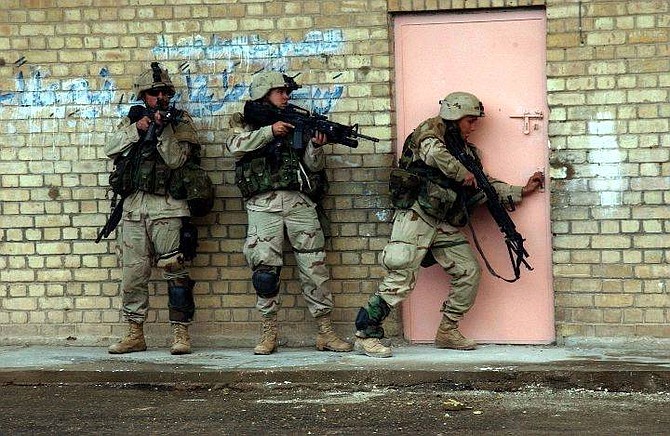 In this picture released by the U. S. Army, soldiers from 2nd Battalion, 5th Cavalry Regiment, 2nd Brigade Combat Team, 1st Cavalry Division, enter a building in Fallujah, Iraq, during Operation Al Fajr (New Dawn), on Tuesday, Nov. 9, 2004. (AP Photo/Sgt. 1st Class Johancharles Van Boers/ U.S. Army/HO)  ** NO SALES**