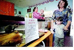 BRAD HORN/Nevada Appeal Charity the rat, from left, Minnette Schrader, her son Shawn DeLaBruere, 1, Jared DeLaBruere, 4, and owner of Charity Thrift Store Beverly Rolfe get ready Friday for the store&#039;s grand opening today.