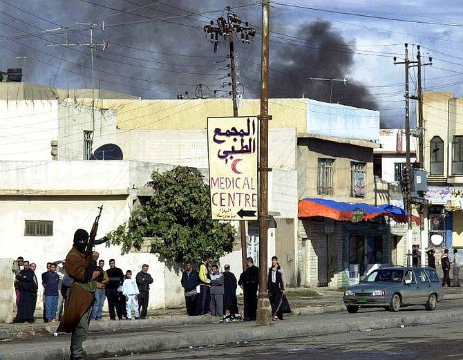 Masked insurgent holds weapon in Mosul Thursday Nov. 18, 2004. Insurgents fired mortars Thursday at the provincial administration offices in the northern city of Mosul, wounding four of the governor&#039;s guards, the U.S. military said. (AP Photo)