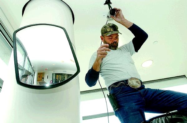 Rick Gunn/Nevada Appeal Desert Hills Video Security Systems installer Steve Henson installs a surveillance camera at the Carson City Courthouse on Wednesday.