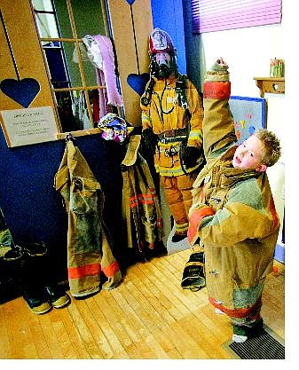 BRAD HORN/Nevada Appeal Kyle Cavner, 7, of Carson City, tries to get in an oversized fireman&#039;s coat at the Children&#039;s Museum on Saturday during the Adoption Fair. Cavner&#039;s mother, Polly, was adopted and plans to adopt a daughter soon.