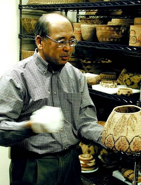 Eugene M. Hattori, Ph.D, curator of anthropology for the Nevada State Museum, displays one of more than 1,200 American Indian baskets in the downstairs vault at the museum.  Peter Thompson/ Nevada Appeal