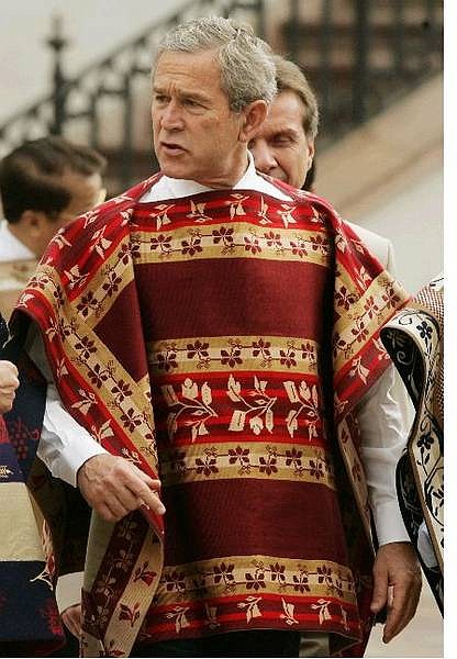 U.S. President Bush, wearing a traditional handmade Chilean poncho pauses during the APEC leader&#039;s official photograph at the Naranjos Courtyard at La Moneda Sunday, Nov. 21, 2004,in Santiago, Chile.  The woolen ponchos were hand-woven by a group of eight women in the town of Donihue, about 200 kilometers (125 miles) south of Santiago, the capital. Each poncho takes up to four months to make. (AP Photo/Pablo Martinez Monsivais)