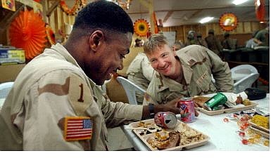 Associated Press Spc. Kevin Pleasant, left, and Spc. Bryan Johnson, both from Fayetteville, N.C., share a laugh as they finish their Thanksgiving dinner at Forward Operating Base Cobra in Iraq Thursday.