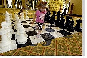 AssociatedPress Cassandra Tanner, 4, runs across a giant chess board as Joshua Guy, 2, moves a piece outside the 2005 U.S. Chess Championships at the Hilton La Jolla Hotel in San Diego Wednesday.