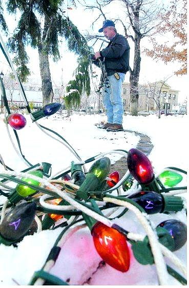 Rick Gunn/Nevada Appeal Bruce Henderson, electrician for the state of Nevada Buildings and Grounds Department, puts up holiday lights at the Capitol on Tuesday afternoon.