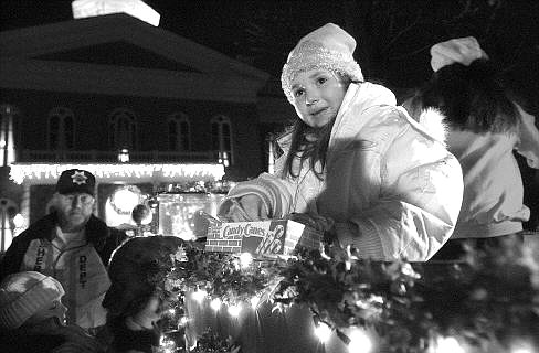 Rick Gunn/Nevada Appeal Autumn Martin, 5, hands out candy canes from a truck carrying Santa on Thursday evening during the annual tree-lighting ceremony at the Capitol. Below, Santa (Rob Davenport) hands out candy canes.
