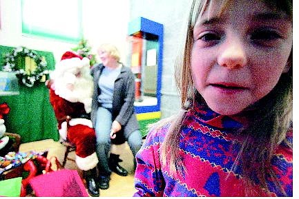 BRAD HORN/Nevada Appeal Hailey Gunter, 7, walks away from Santa Claus while her mother Tassier Beitler asks Santa for Christmas gifts at the Children&#039;s Museum of Northern Nevada on Saturday. Below, Santa gives Donald Hurst, 5, a candy cane.