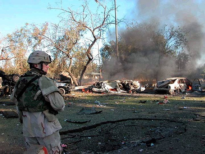 In this photograph released by the U.S. Army, Sgt. Dustin Miller of F Troop, 9th Cavalry stands guard near the crater of a car bomb that exploded near a checkpoint to the International Zone in central Baghdad, Monday, Dec. 13, 2004.  (AP Photo/US Army,  Sgt. John Queen)