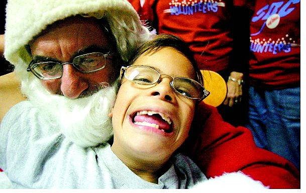 BRAD HORN/Nevada Appeal Ivan Rosas Medina, 11, sits on Santa&#039;s lap at Fremont Elementary School Thursday afternoon.