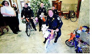BRAD HORN/Nevada Appeal Sgt. Randy Smith on Friday rides one of the 16 bikes Capitol Police bought for needy children in the lobby of the Capitol. Pictured in background from left is Salvation Army Capt. Erica Helton, officer Chuck Brummer, Sgt. Sam Logar and Capitol Police Chief Brad Valladon. Valladon said the money they were able to raise went further this year because Wal-Mart provided discounts and the Department of Public Safety Office of Traffic Safety contributed helmets to go with the bicycles. Other officers who helped with the donations in addition to Valladon, Smith, Brummer and Logar are Ken Hewlett, Stan McGarry, Mike Bushley, Mike Petti, Clark Mann, Michael Fox, Jay Logue and Art Rumple. In addition, Keri Halvorsen and Sgt. Tony Garparino of Las Vegas contributed.