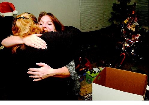 Rick Gunn/Nevada Appeal Single mother Victoria Ostin, right, hugs Toys for Tots volunteer Pat Wyble after receiving a host of Christmas gifts, including toys, school supplies, bicycles, food, haircuts, movie and restaurant vouchers Wednesday.