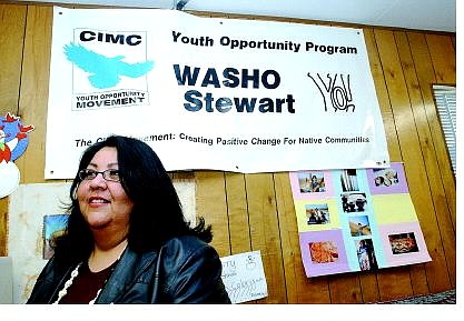 Rick Gunn/Nevada Appeal Debbie Lundy Painter, youth development specialist for the California Indian Manpower Consortium, sits by a banner near her office.