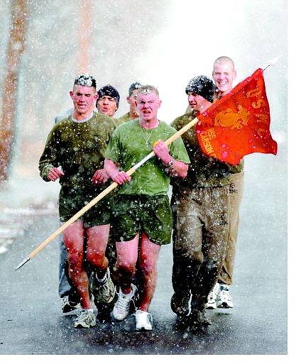 Brad Horn/Nevada Appeal Pvt. Sean Smith, from left, Pfc. Vicente Coronado, Lance Cpl. Michael DeWitt with flag, Pvt. Jason Hayes and Pvt. Kevin Brown brave snowy conditions to jog on Roop Street in Carson City on Wednesday. The Marines are on a 10-day leave.