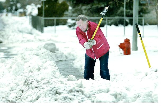 Cathleen Allison/Nevada Appeal Egon Svendsen, 70, clears the snow and ice from the sidewalks around his Carson City home on Monday. Northern Nevada will continue to see unsettled weather through the week as two storms approach the area from the north.