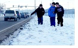 Rick Gunn/Nevada Appeal William Withrow, 10, from left, Michael Daggett, 11, and Zack Peterson, 11, struggle through the snow-covered sidewalks of Roop Street near Little Lane on Wednesday.