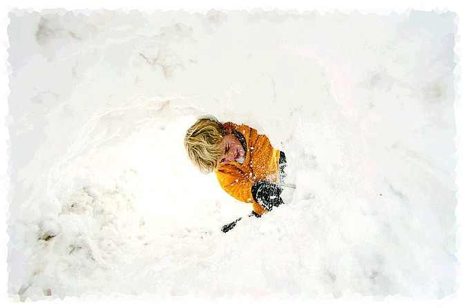 Brad Horn/Nevada Appeal Nolan Shine, 7, of Carson City, digs a snow tunnel in his front yard during a break in the snowstorm on Saturday.