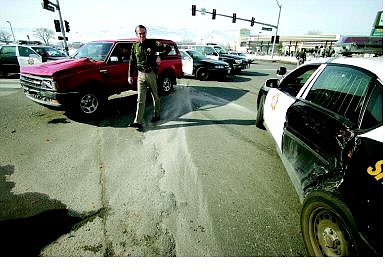 BRAD HORN/Nevada Appeal A Carson City Sheriff&#039;s deputy walks in front of a truck that collided with Deputy Glenn Fair&#039;s patrol car at the intersection of Graves Lane and Highway 50 Saturday.